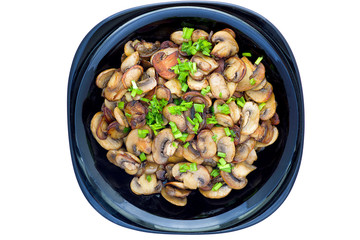 Fried mushrooms with green onion on a black plate isolated