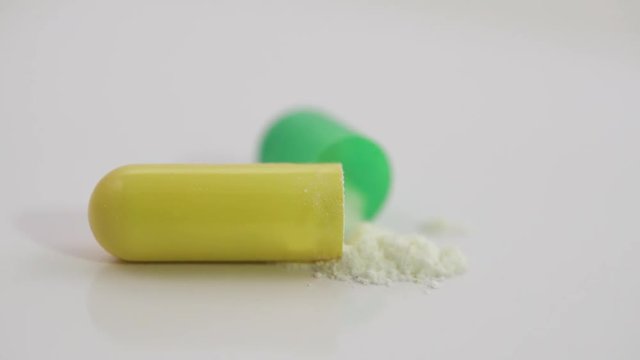 Pharmaceuticals and drugs, view of the opened capsule with medicine, isolated.
