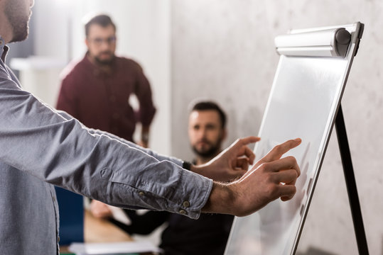 businessman pointing on something at flipchart in office