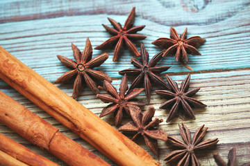 Star anise and cinnamon sticks on wooden background closeup