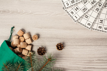 Wooden lotto barrels with bag and game cards, Christmas fir tree branches and cones