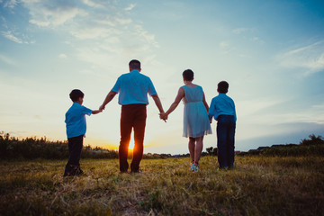 Happy family on the background of the sunset