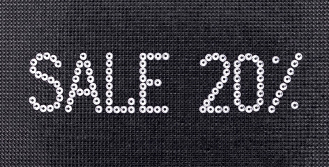 Word SALE is made rhinestones crystal color on a black canvas background.