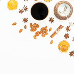 Christmas composition with coffee mug, almond nuts and cinnamon on white background. Flat lay, top view