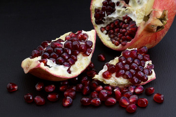 Cut pomegranate on a black background.