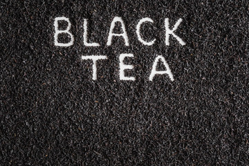 Inscription black tea created on dried, loose tea. Enjoying of tea break at the work, at home, at visit with friends, family or alone everyday. Top view.