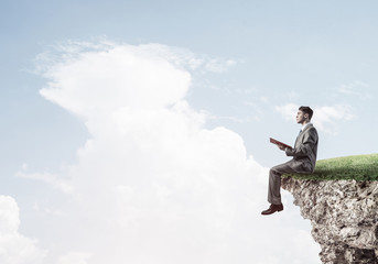 Student guy in suit with book in hands preparing for exam