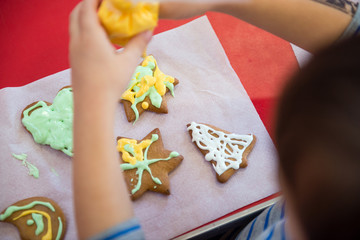 Kid decorates Christmas cookies