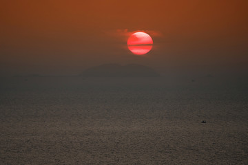 Sunset at sea with island and boat.