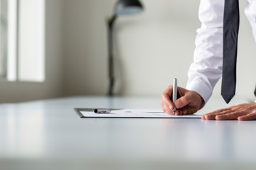 Man in white shirt signing contract or subscription form