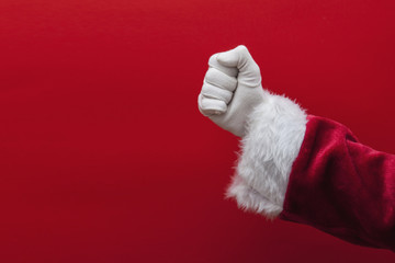 Santa Claus hand in fist against a red background