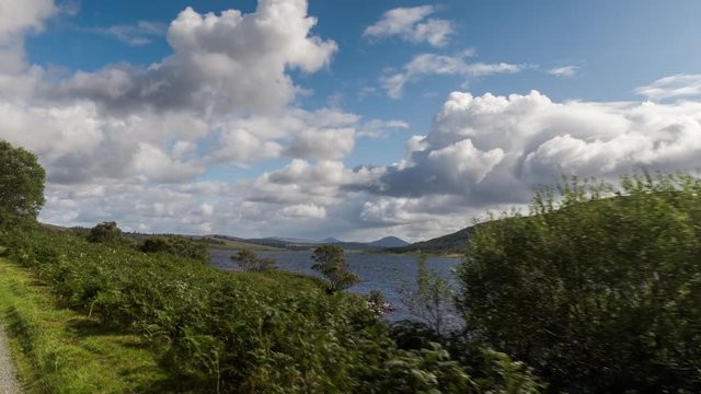 POV shot from a camera attached to the front of a vehicle driving through beautiful empty roads in the scottish highlands