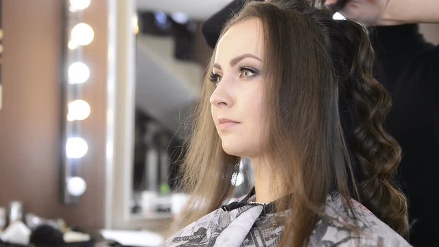 Woman with long hair in a beauty salon, make a styling