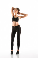 Fototapeta premium Full length image of Smiling fitness woman posing in studio
