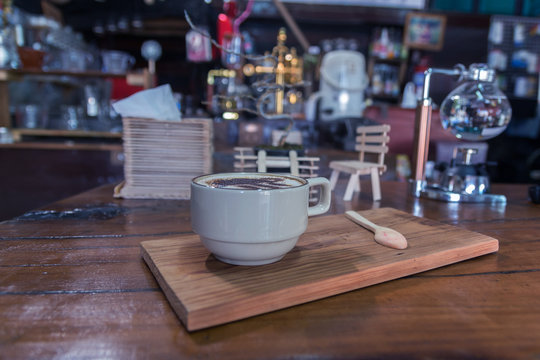 Cup of coffee on wooden dable in the coffee shop.