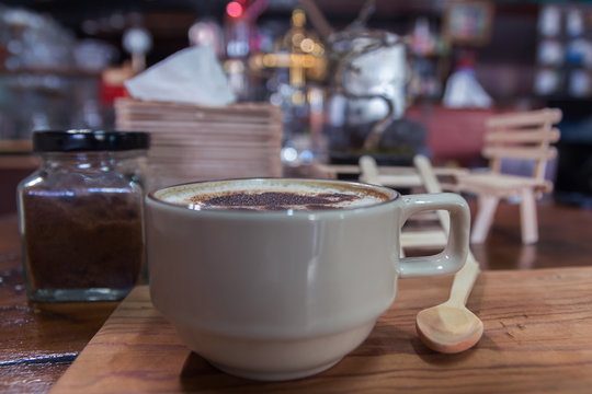Cup of coffee on wooden dable in the coffee shop.