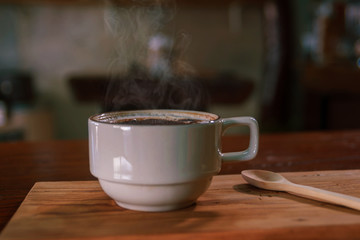 Cup of coffee on wooden dable in the coffee shop.