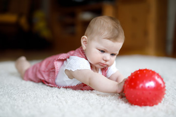 Fototapeta na wymiar Cute baby girl playing with red gum ball.