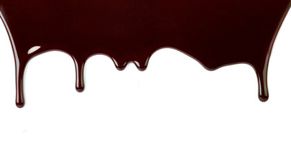 close up of chocolate syrup leaking on white background