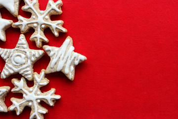 Christmas cakes in icing in the shape of snowflakes and stars closeup on red background