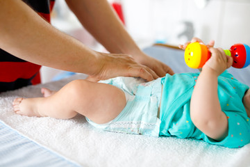 Close-up of father changing diaper of his newborn baby daughter.