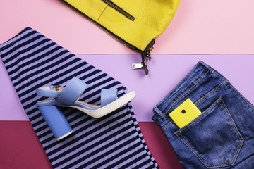Bright women's accessories and clothing on a lilac background. The view from the top. Flat lay.
