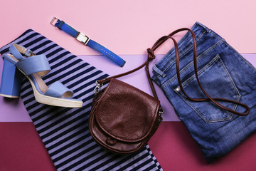 Bright women's accessories and clothing on a lilac background. The view from the top. Flat lay.