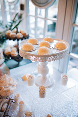 Candy bar and wedding cake with flowers. Table with sweets, buffet with cupcakes, candies, dessert.