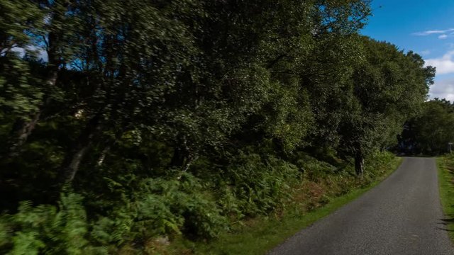 hyperlaspe POV shot from a camera attached to the front of a vehicle driving through beautiful empty roads in the scottish highlands