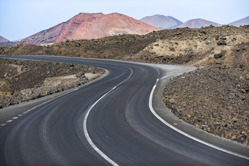 A winding asphalt road among lava poles on Lanzarote Canary Islands