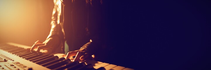 Mid section of musician playing piano - Powered by Adobe