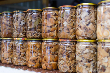 Pickled mushrooms in a glass jar in assortment