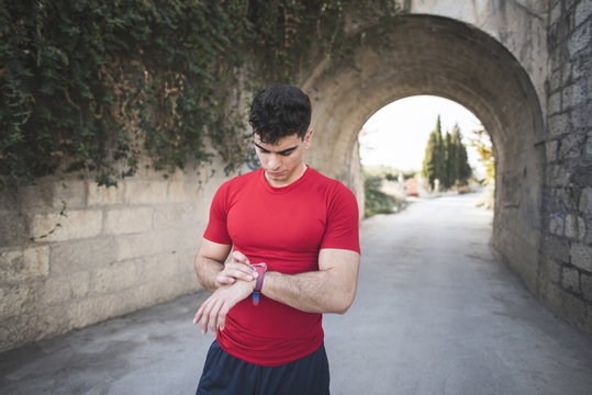 Young runner loking his smart wach after training