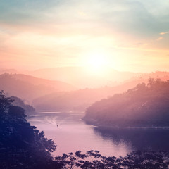 Beautiful mountain river landscape at sunset with mist and calm water surface © Choat
