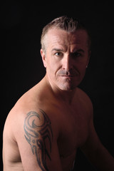 Fototapeta premium portrait of a man with tattoo and black background