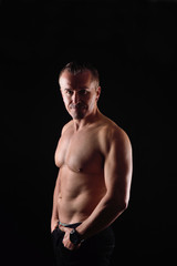 Fototapeta na wymiar portrait of a man with naked torso on black background