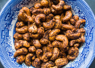 Baked cashews in blue dish.