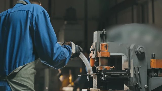 Factory employee using modern cutting lathe for make hole in metalworking detail