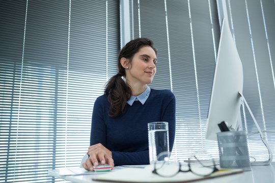 Female executive working on desktop pc at desk