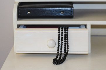 Abstraction on a dressing table black beads and a photo album