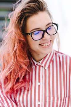 Portrait Of Young Beautiful Girl Wearing Stylish Shirt, Black Skinny Jeans, Glasses. Girl Have Shinny Long Red Hair. Female Fashion Concept