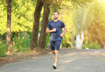 Fototapeta na wymiar Sporty young man running in park