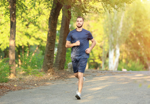 Sporty young man running in park