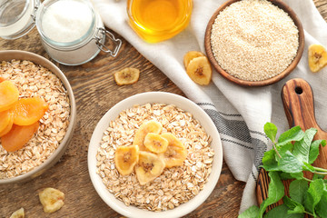 Composition with oatmeal flakes and toppings on wooden background