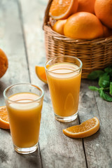 Glasses of fresh orange juice on table