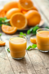 Glasses of fresh orange juice on table