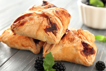 Puff pastries with blackberries on wooden table