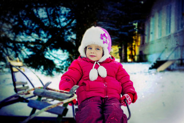 Little girl standing on a snowy street 