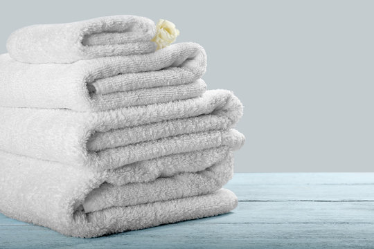 Clean towels on table against light background