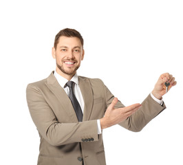 Attractive real estate agent holding key on white background